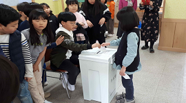 분원초 학생이 투표함에 투표지를 투입하고 있는 장면