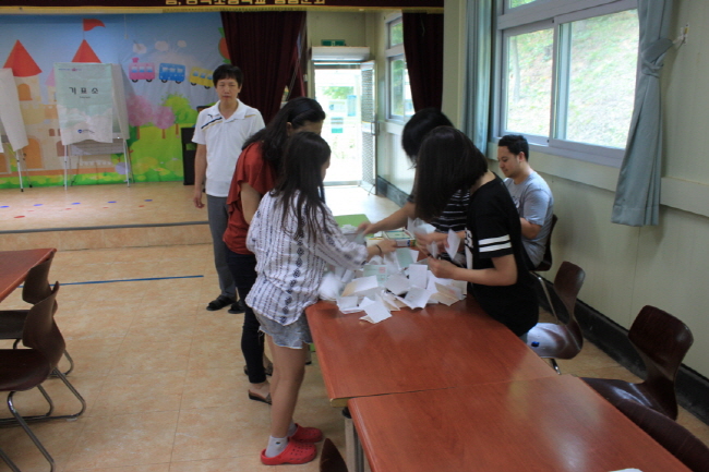 송곡초등학교 어린이들이 투표가 모두 투표가 끝나고 후보자별로 투표수를 분류하고 있는 모습의 사진