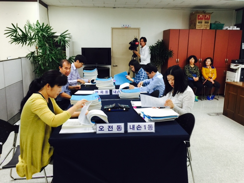 위원회 직원들이 위원회 사무실에서 주민소환투표청구서명부를 확인하고 있는 모습