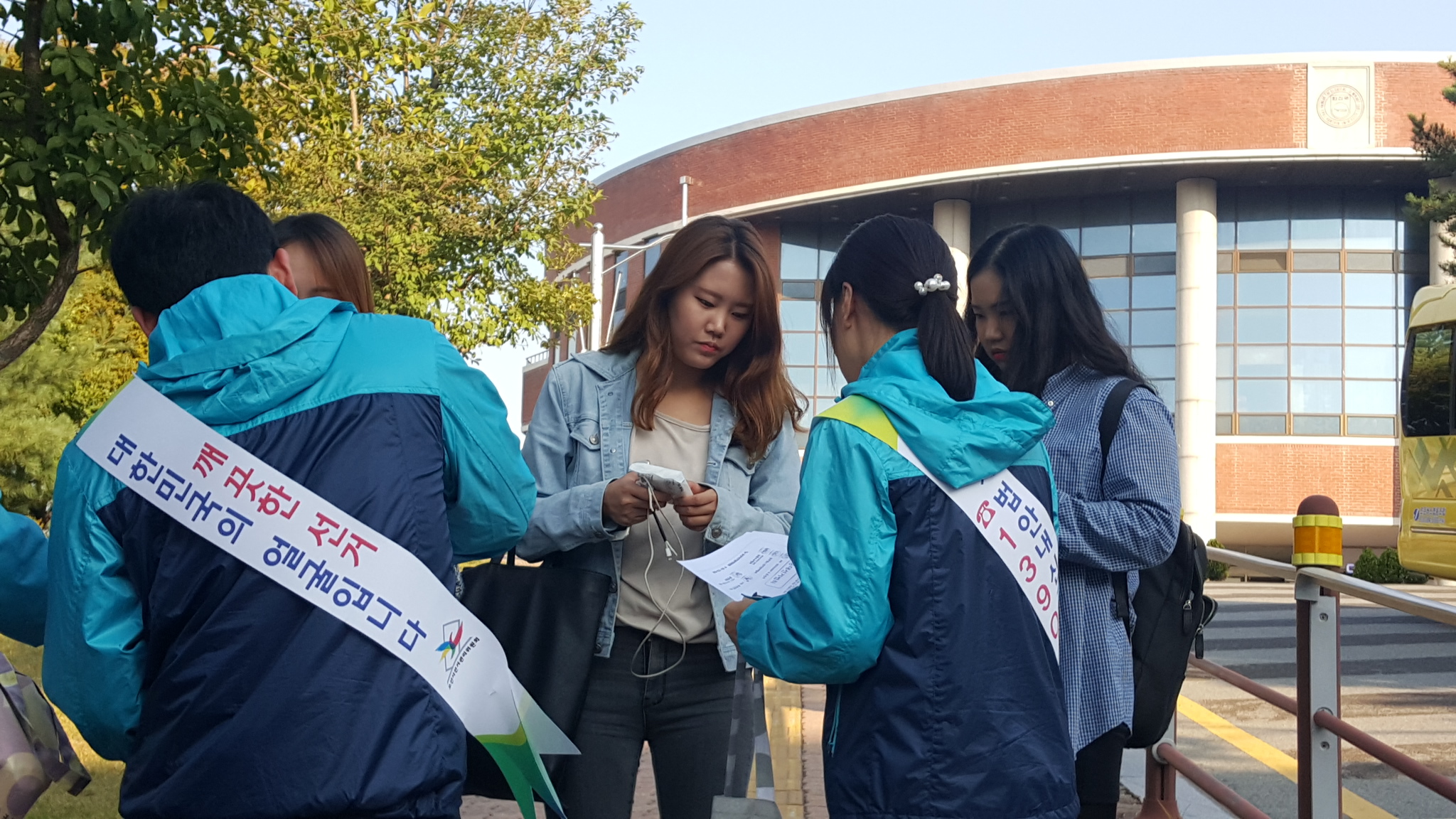 오산시선관위 직원들이 한신대학교 학생들에게 홍보용품을 나눠주며 내년에 있을 제20대 국회의원선거의 투표참여를 당부하는 모습