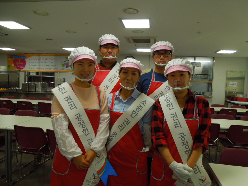 배식봉사 시작 전 과천노인복지관 식당에서 홍보 어깨띠를 착용한 직원들의 단체사진