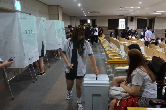 기표를 마친 학생이 투표용지를 투표함에 넣고 있는 모습
